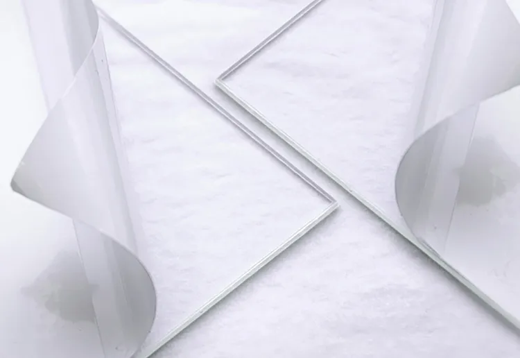 Two acrylic glazing sheets on white paper with their protective film peeled back
